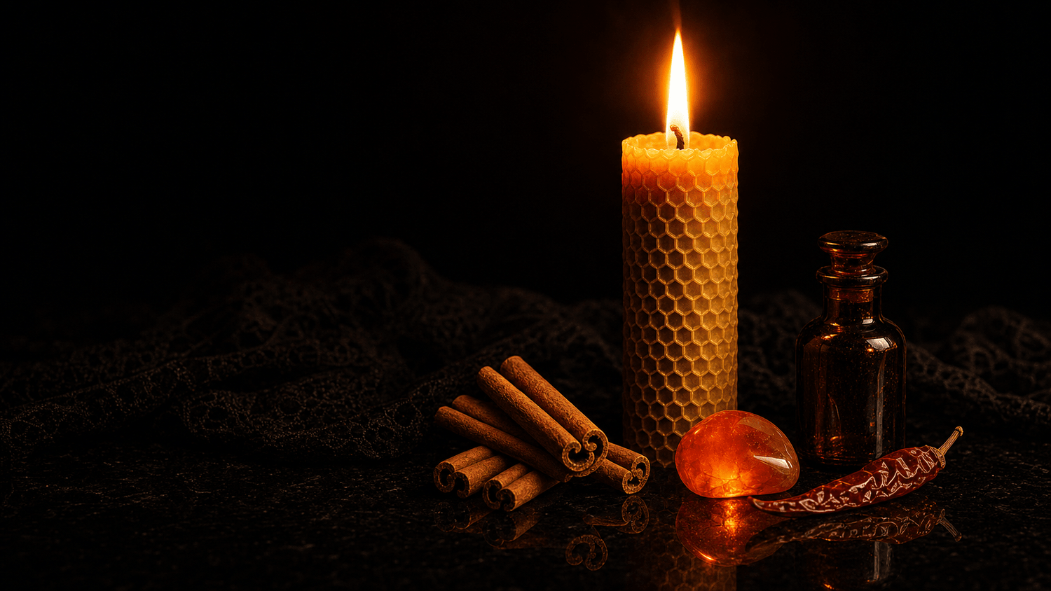 A close-up of a flame rising from a ritual candle surrounded by red and orange botanicals, cinnamon sticks, and a dark glass anointing bottle on obsidian stone